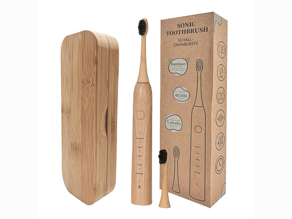 A bamboo electric toothbrush with black bristles is standing upright in the middle. Besides it is a additional bamboo case and recyclable eco packaging for the product